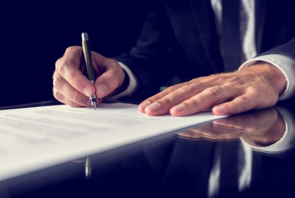 What Types of Cases Qualify for Legal Funding blog. Image of a person signing a document.