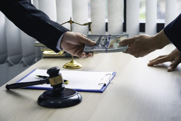 What Role Does Legal Funding Play in Personal Injury Cases? Image of cash changing hands in a legal setting.