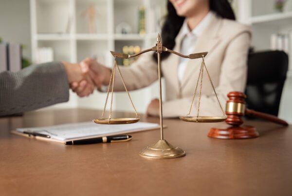How to Prove Lost Wages in a Personal Injury Case. Image of a handshake deal taking place in a legal office.