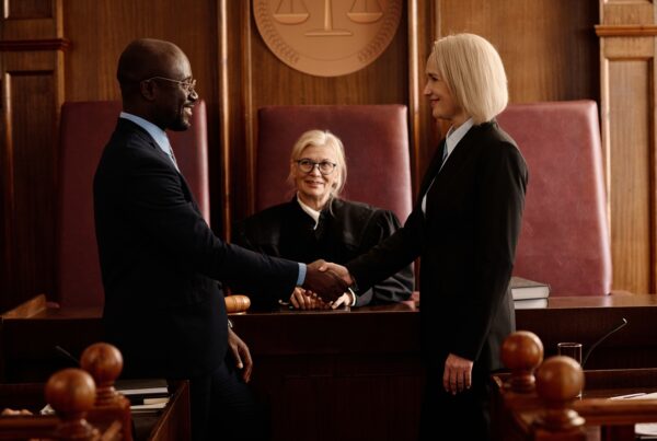 How Pre-Settlement Funding Works for Slip and Fall Cases. Image of two lawyers shaking hands in front of a judge in a courtroom.