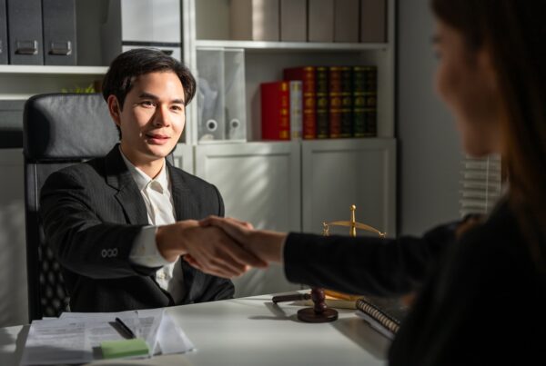 Legal Funding vs. Traditional Loans: What's the Difference? Image of a handshake deal in a law office.