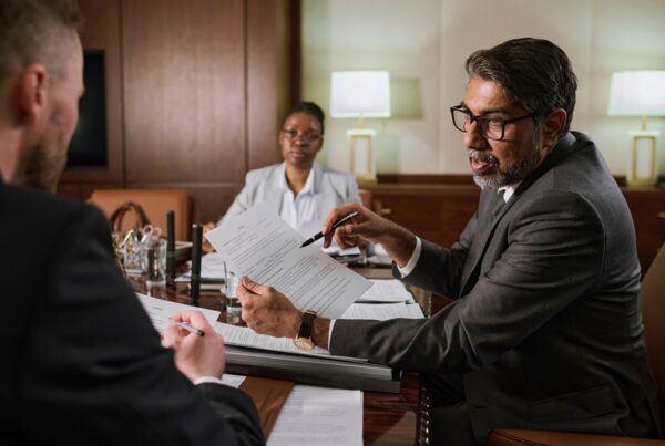 Understanding Non-Recourse Funding: What It Really Means for Plaintiffs. Photo of a meeting between 3 people in a legal office.